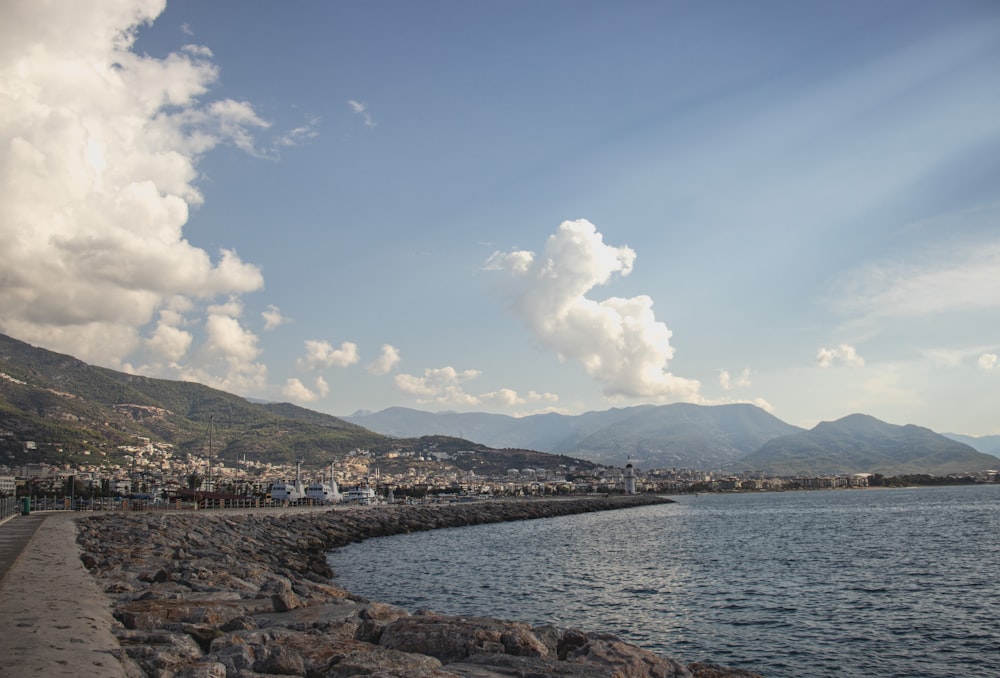 a body of water with a town by it and mountains in the background