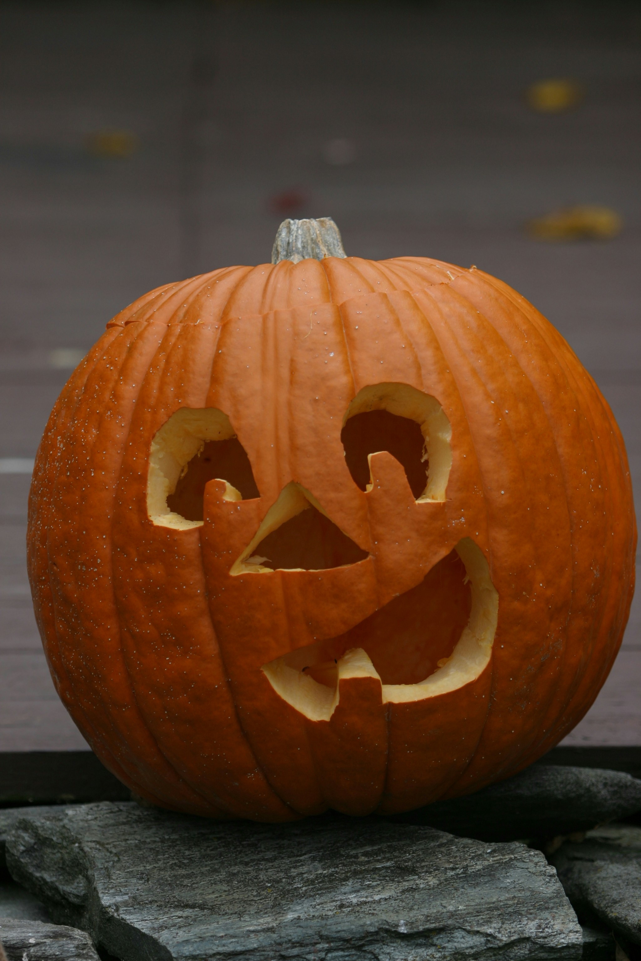 a carved pumpkin on a stone