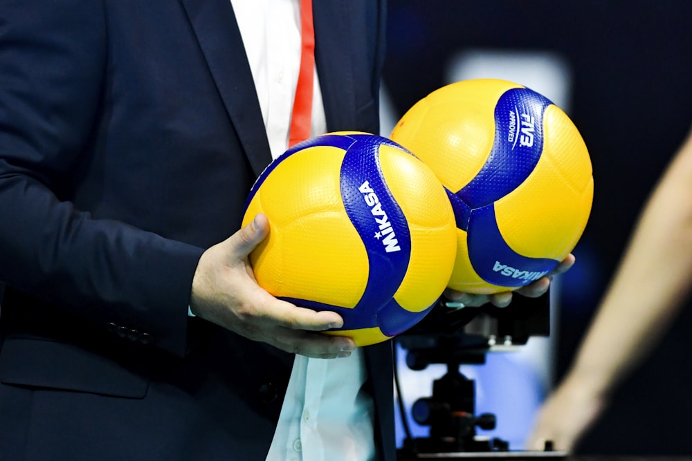 a person holding a blue and yellow ball