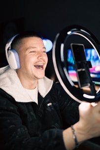 A smiling influencer recording a tech review in a well-lit, minimal studio.