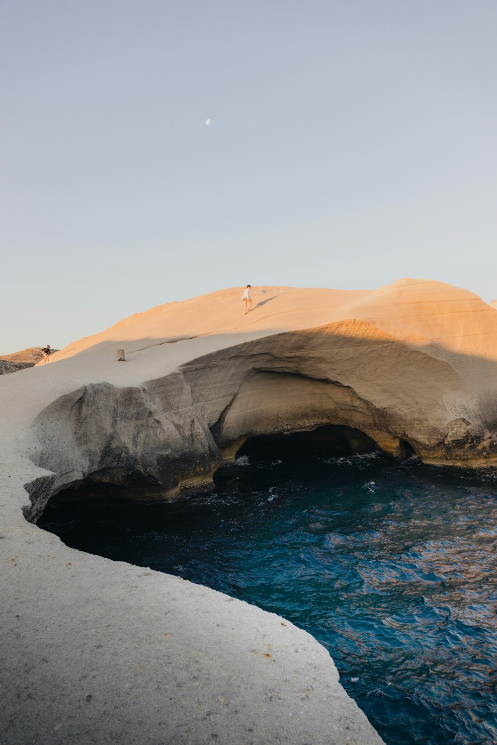 a large rock arch over a body of water