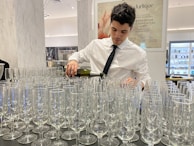 A sommelier pouring La Châtelaine wine at a stylish hospitality event.