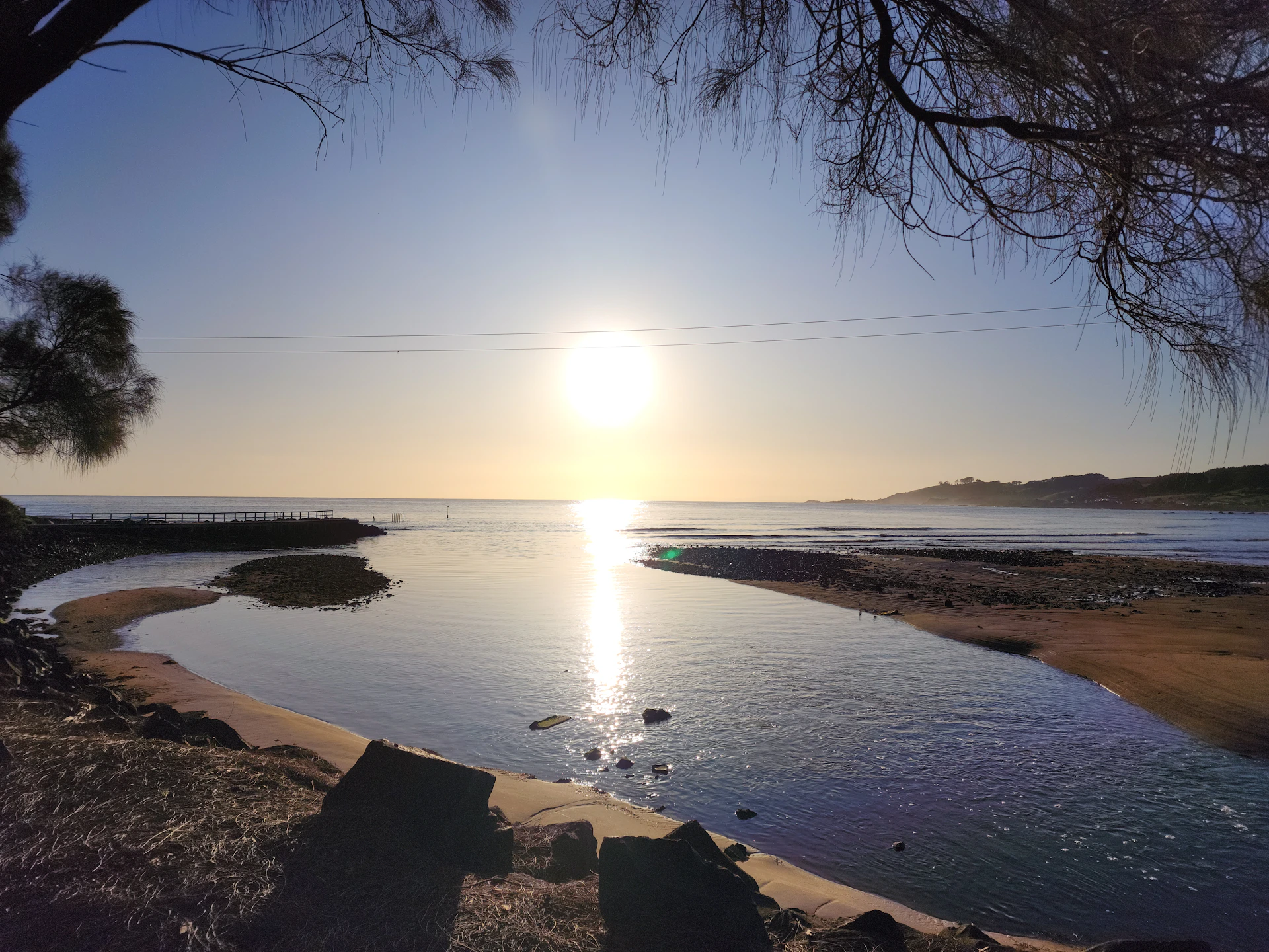 A serene sunrise over the Almería coastline, capturing soft golden light reflecting on the water.