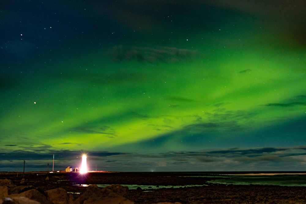 a green and purple sky with a bright light in the middle