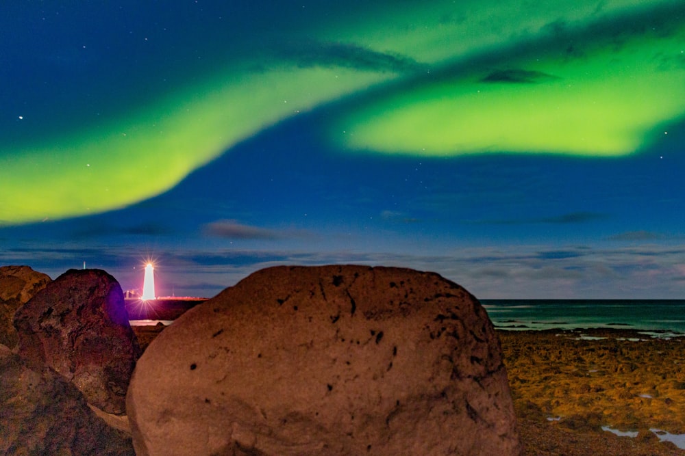 a rocky beach with a bright light in the sky above