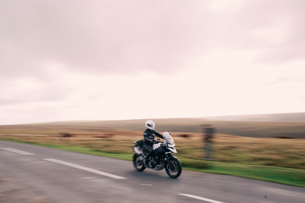 Un uomo che guida una motocicletta su una strada