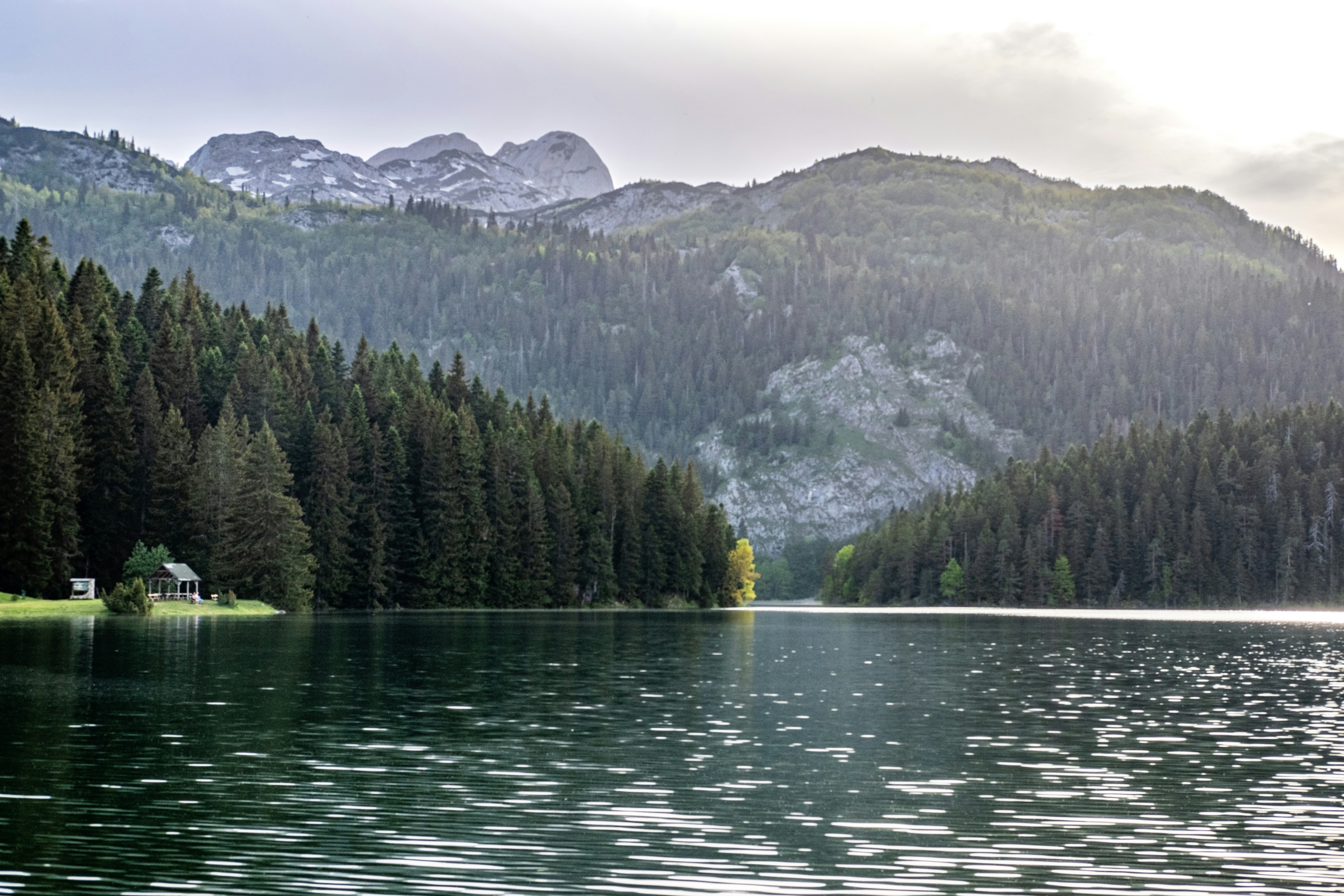 a lake with trees and mountains in the background