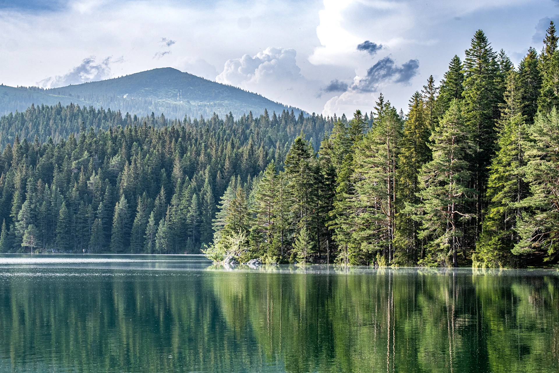 a lake with trees and mountains in the background