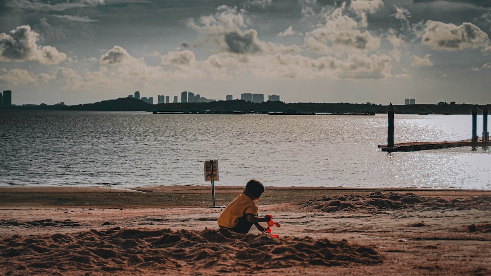 un bambino che si siede su una spiaggia