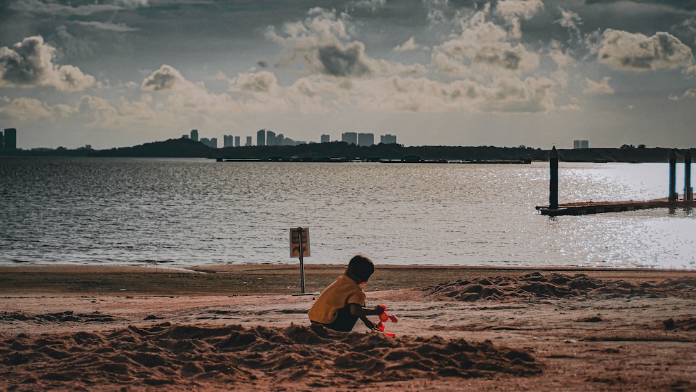 uma criança sentada em uma praia