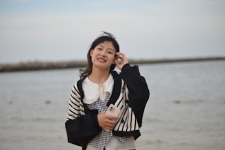 A peaceful scene of a person smiling while holding a phone, reading their horoscope on kaliastro.com.