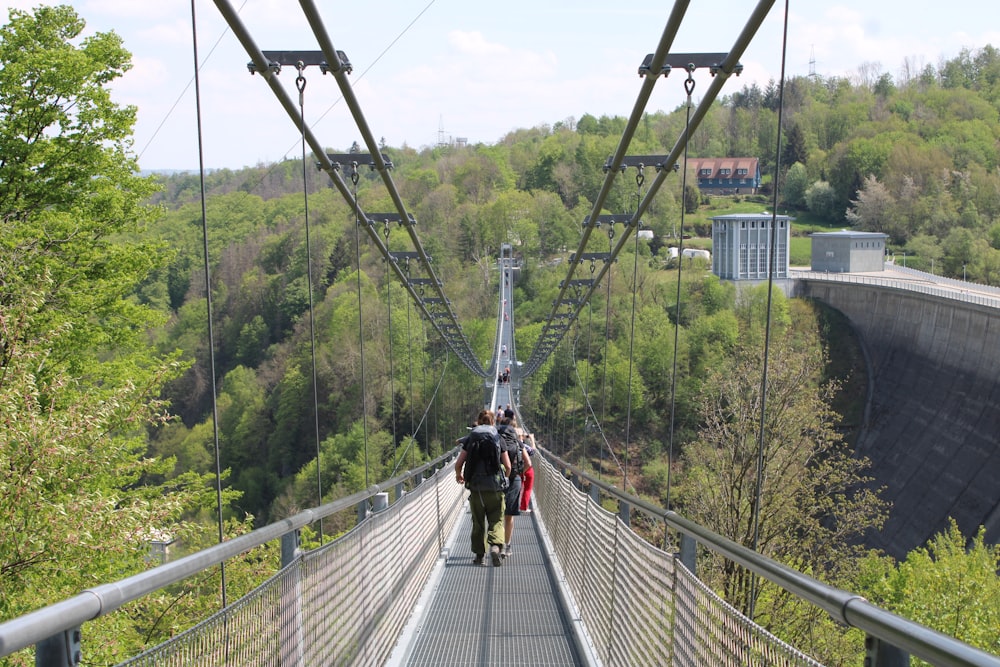 a man and woman walking on a suspension bridge