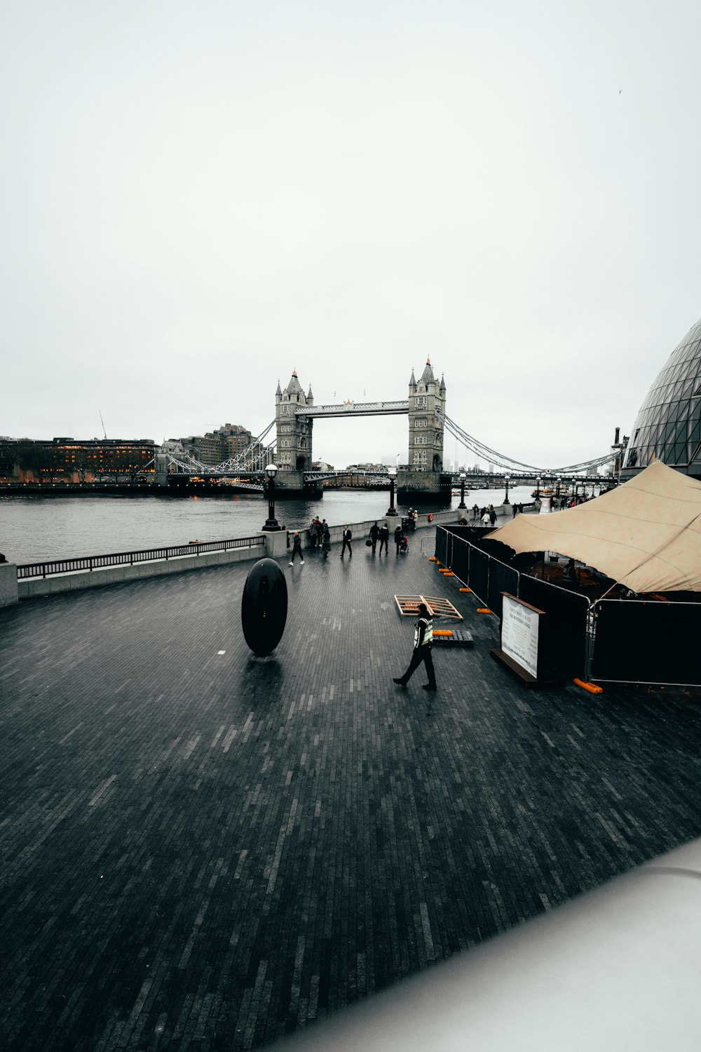 a bridge with a tower and people walking on it