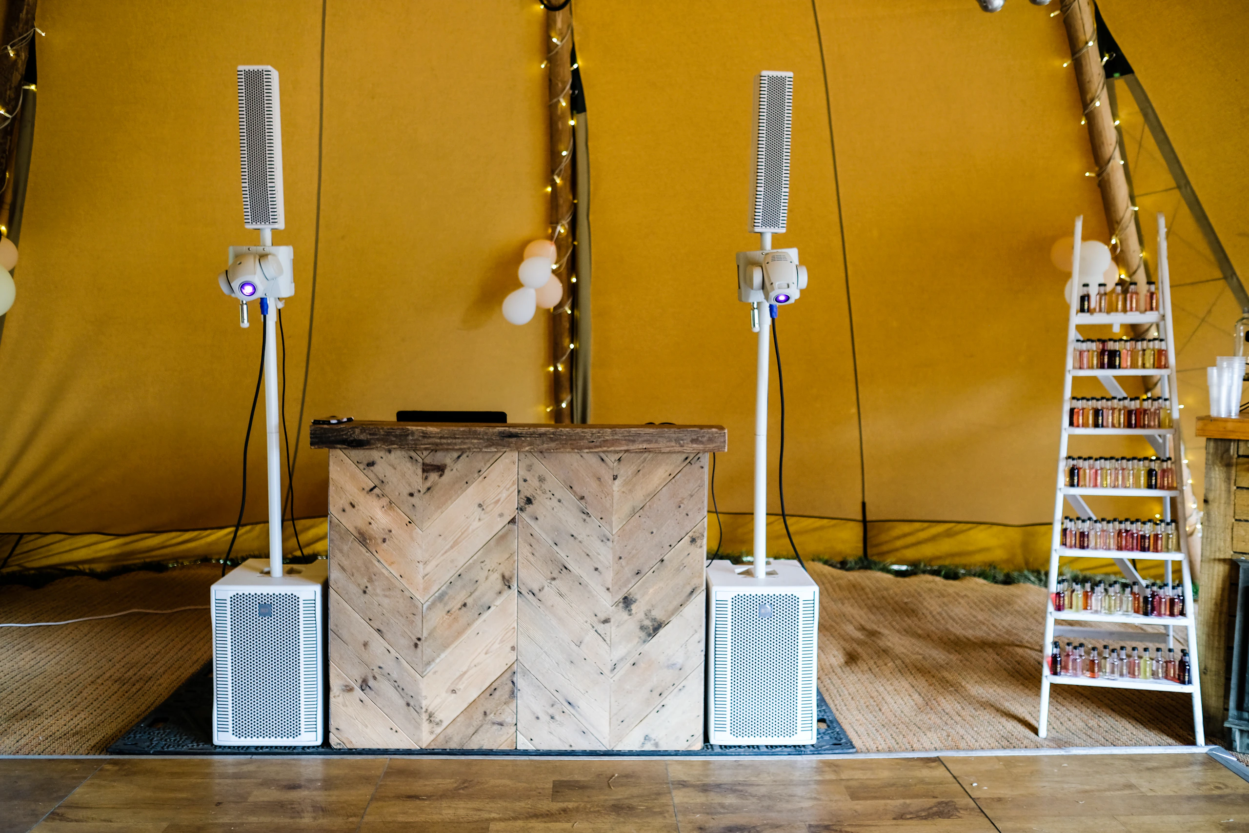 A DJ booth with a wooden facade set up for a reception