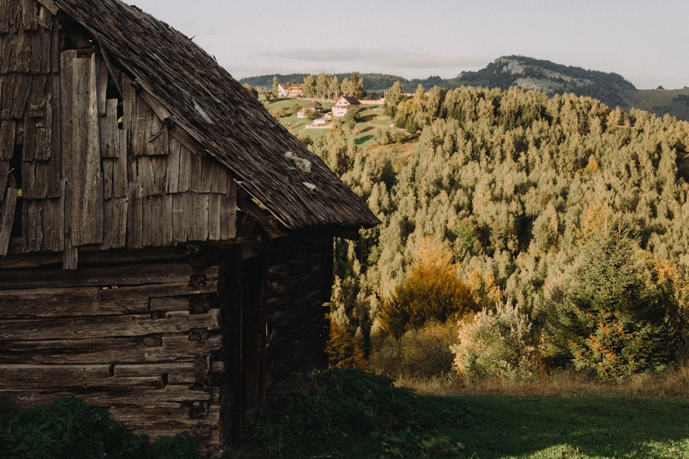 a wooden building with a hill in the background