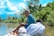 Image of a happy man on a boat with the Similan Islands in the background under a bright blue sky.