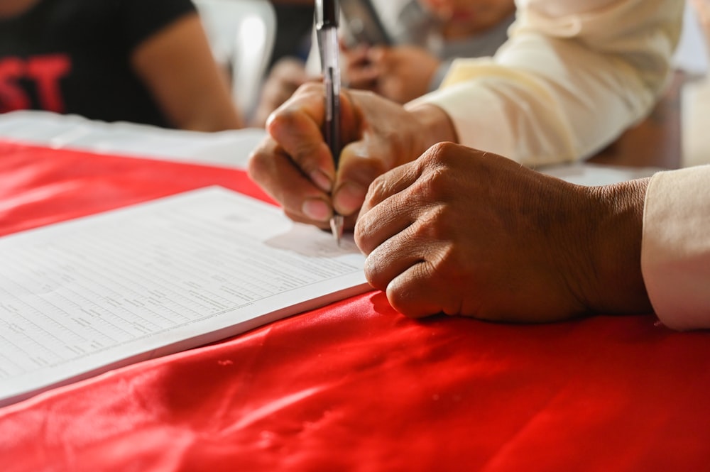 a person writing on a piece of paper