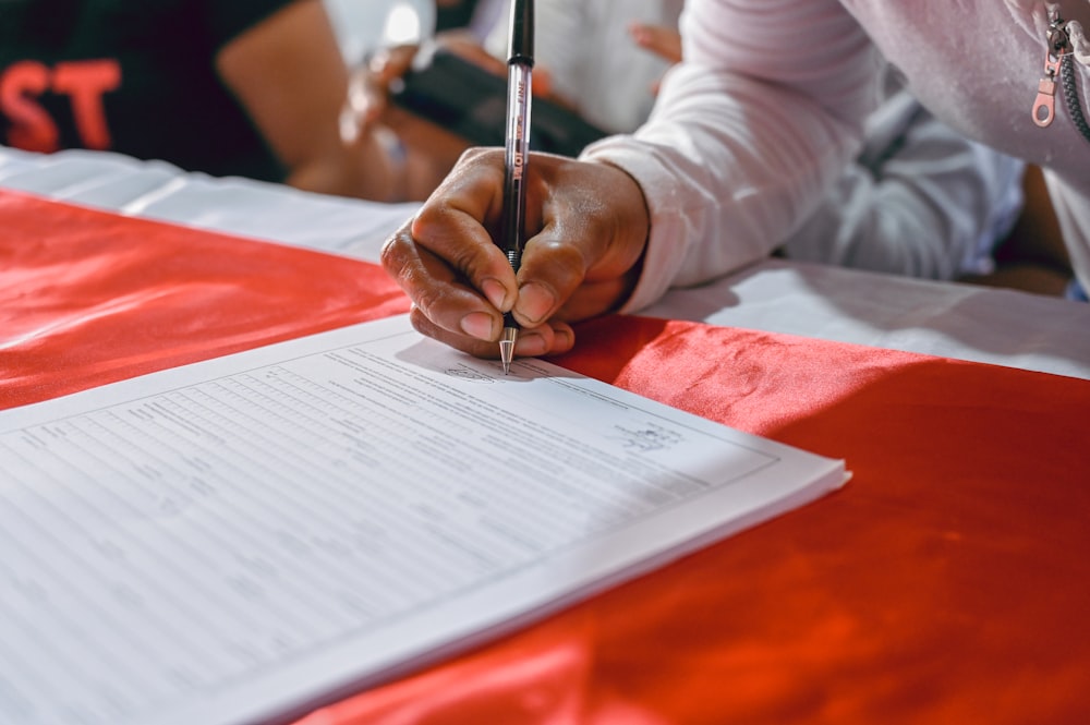 a person writing on a piece of paper