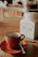 A warm, rustic kitchen scene with a cup of hot panela drink and a small sack of panela blocks on a wooden table.