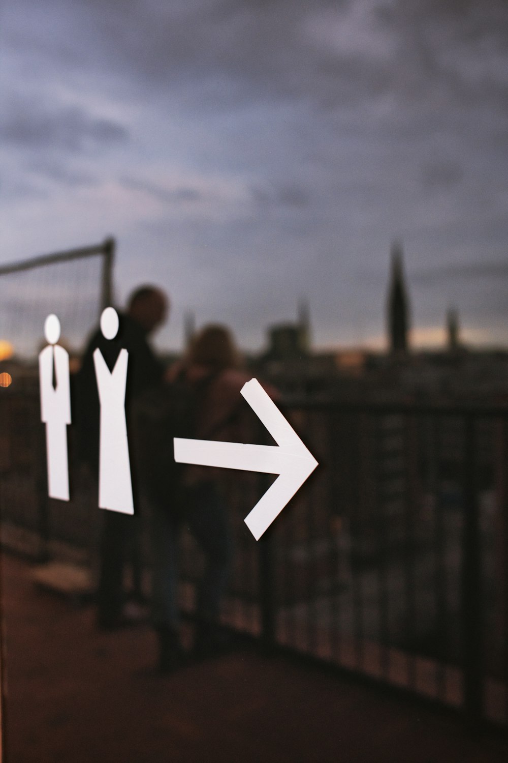 a group of people standing on a bridge with a sign on it