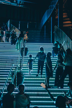 Futuristic concept art of mobile gamers climbing digital steps glowing with neon accents symbolizing growth.