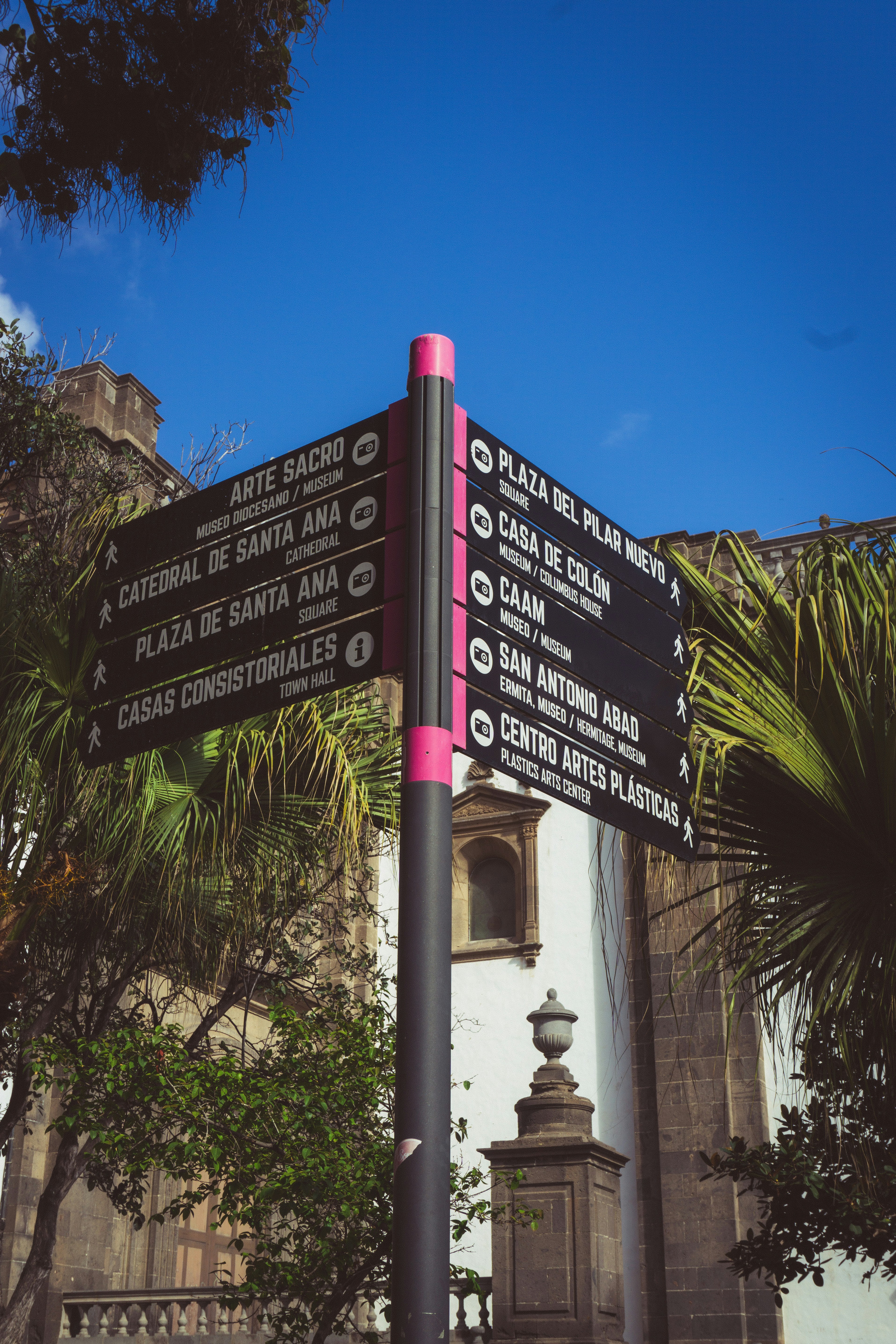 Un letrero de la calle con un cono rosa en la parte superior