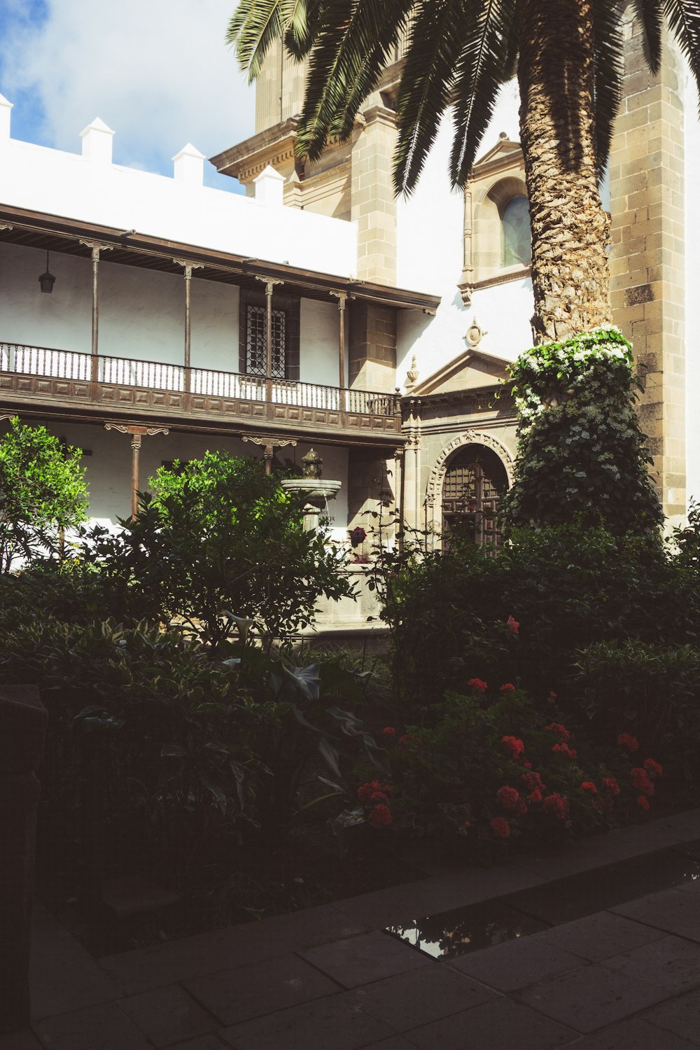 ein Gebäude mit Balkon und Palmen