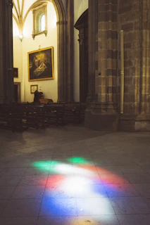 Interior view of the Basilica di Sant'Anastasia al Palatino with sunlight streaming through stained glass windows