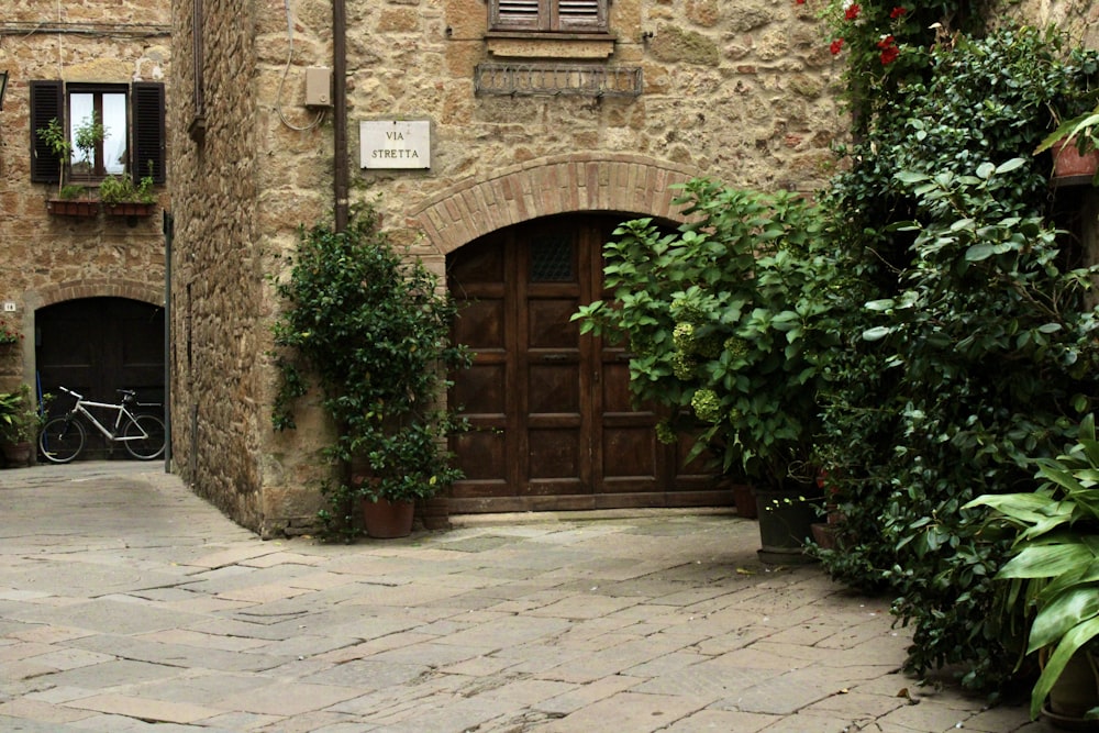 un edificio con una grande porta e piante di fronte ad esso