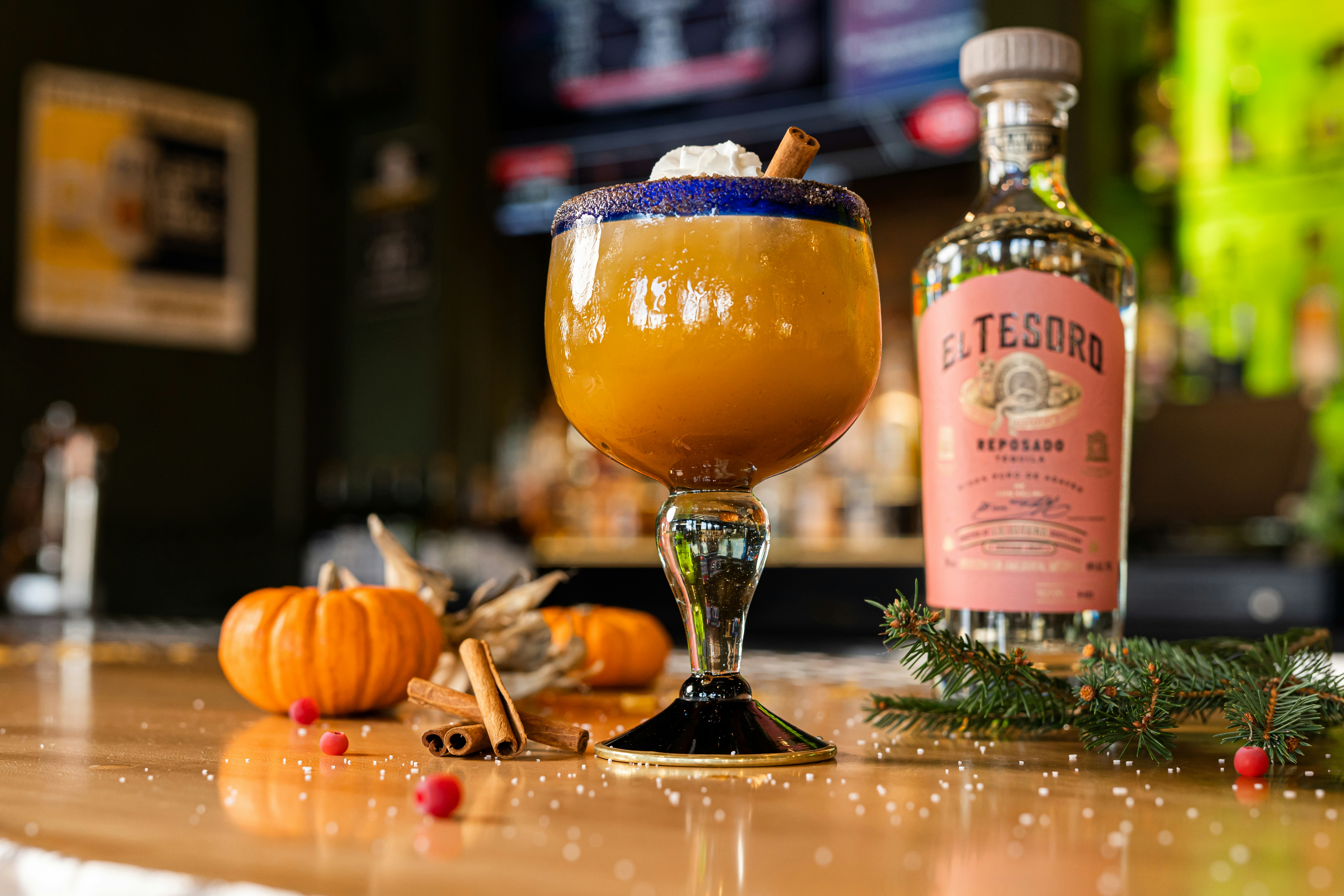 a glass of beer next to a bottle of liquor and a glass of beer