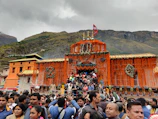 A vibrant temple adorned with marigold garlands and pilgrims immersed in prayer during a spiritual festival.