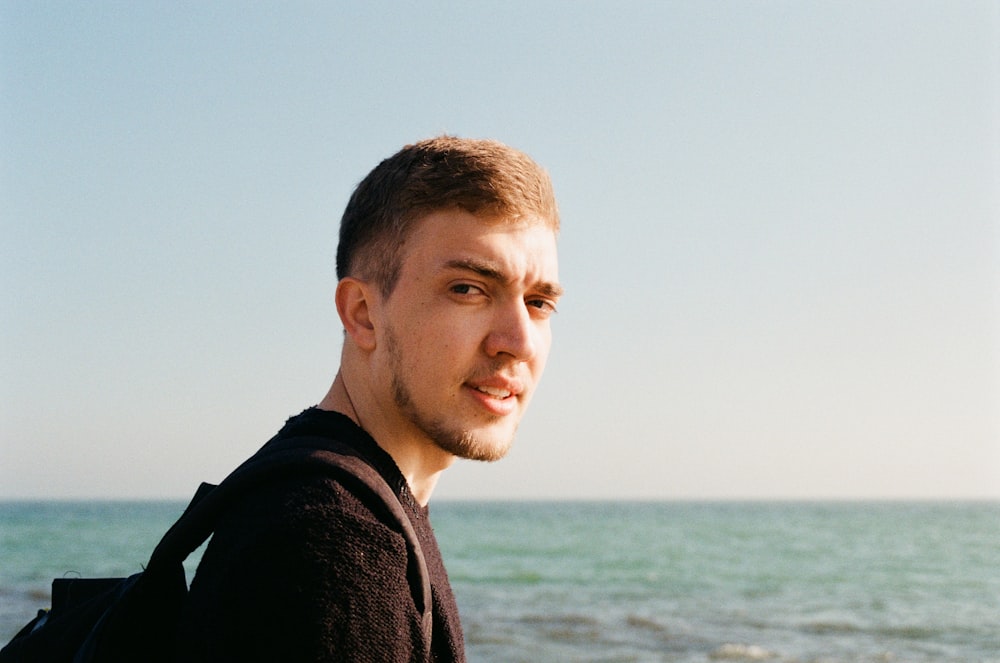 a man standing in front of a body of water