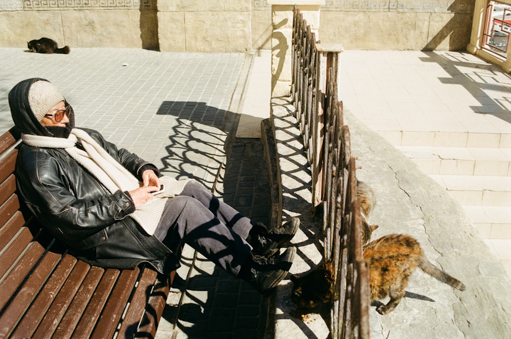 a person sitting on a bench with a cat