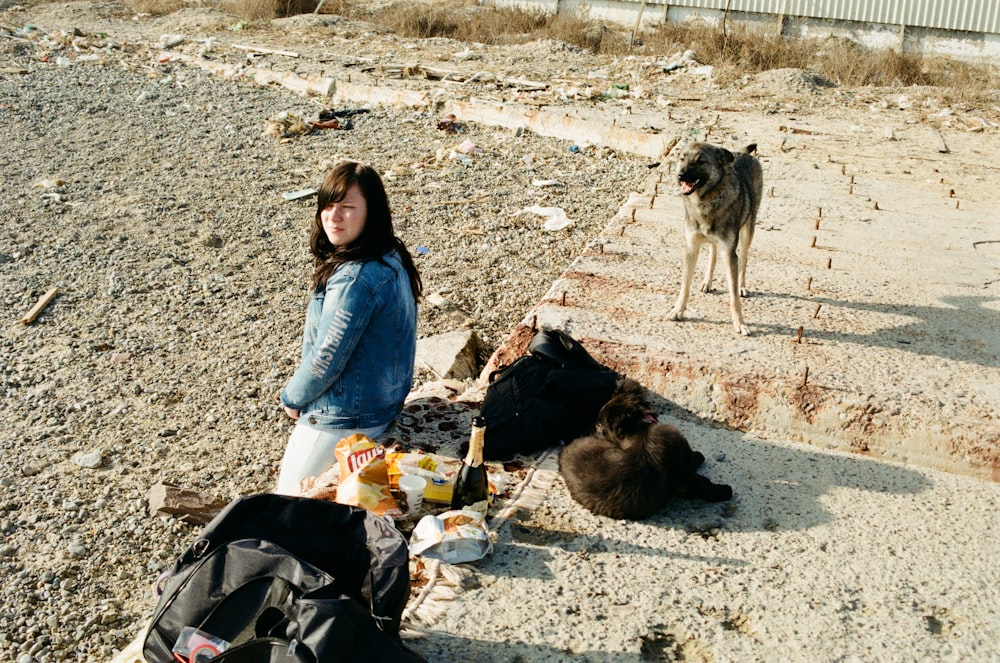 a person sitting on the ground with dogs