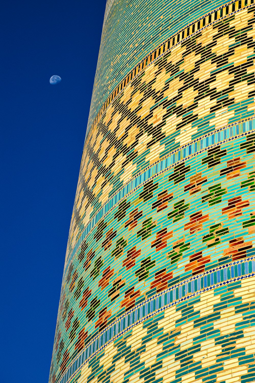 a tall building with a moon in the sky