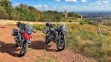 Motorcycles lined up beside a rustic wooden cabin in the Norwegian countryside.