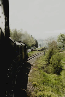 A vintage train traveling through the lush Bordeaux countryside.