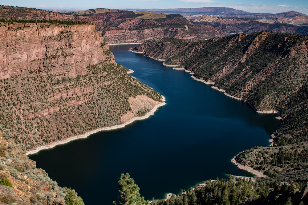 a river running through a canyon with Flaming Gorge Reservoir in the background