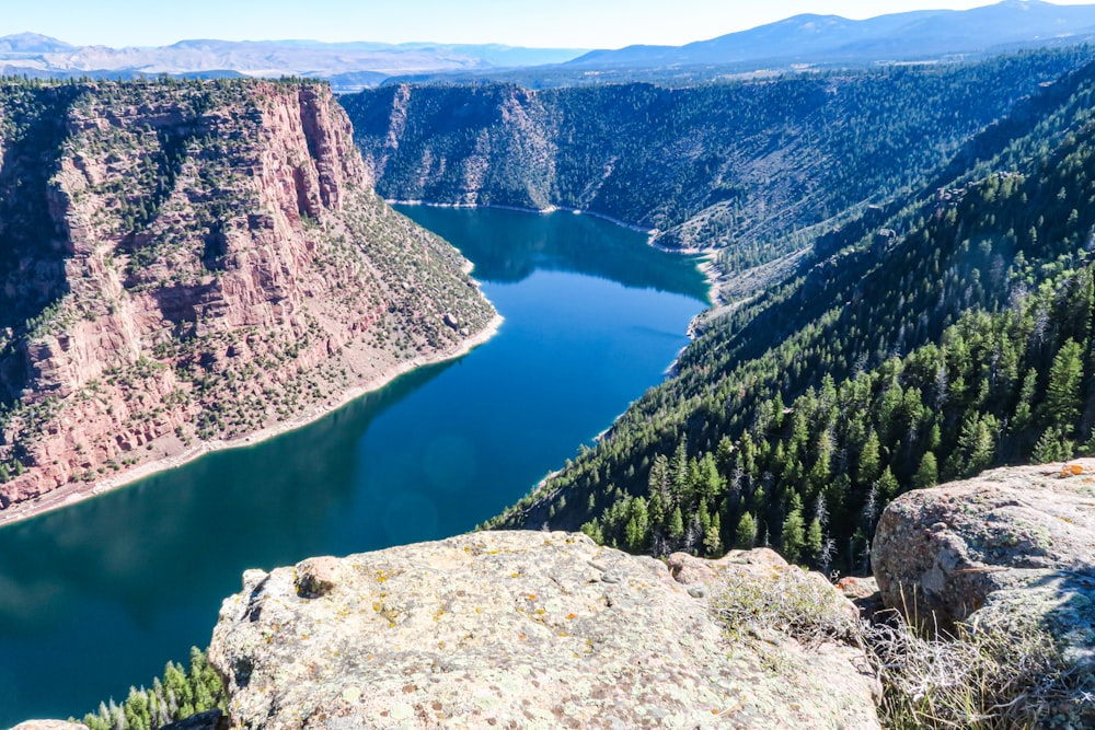 a river running through a valley with Flaming Gorge Reservoir in the background