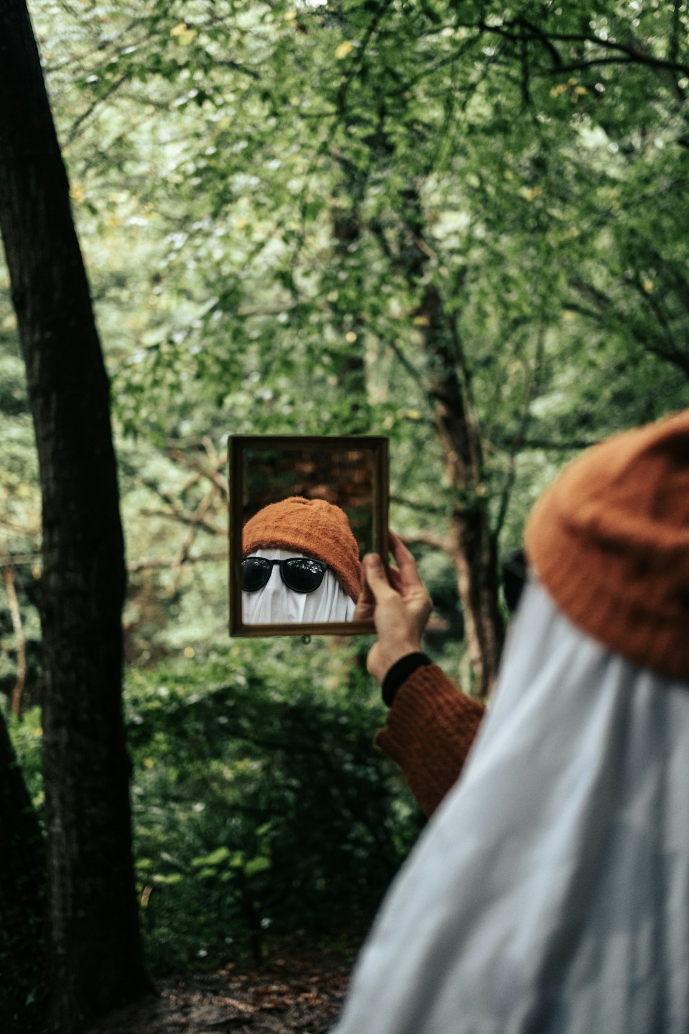 a person holding a picture of a man in a hat