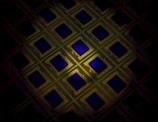A pattern of square chips arranged in a grid, each featuring a prominent blue center surrounded by a greenish-brown circuit-like design. The lighting emphasizes the central area, creating a vignette effect around the edges.