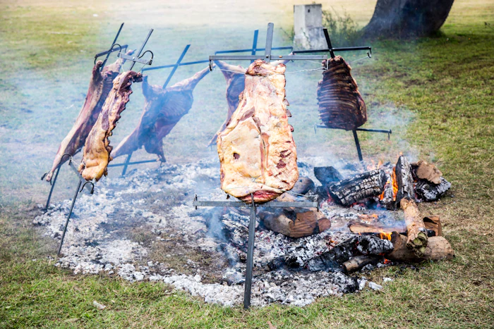 Achuras y chorizos dorándose en la parrilla