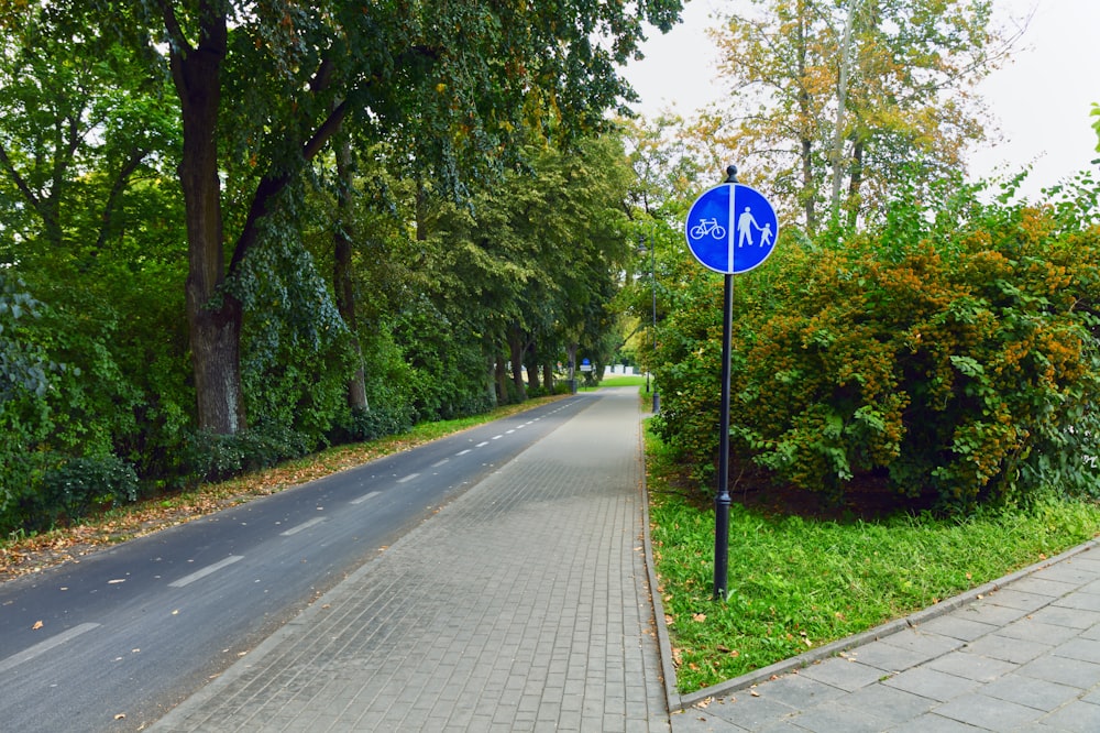 a blue sign on the sidewalk