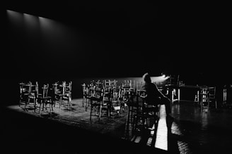 a person sitting on a chair in front of a row of chairs