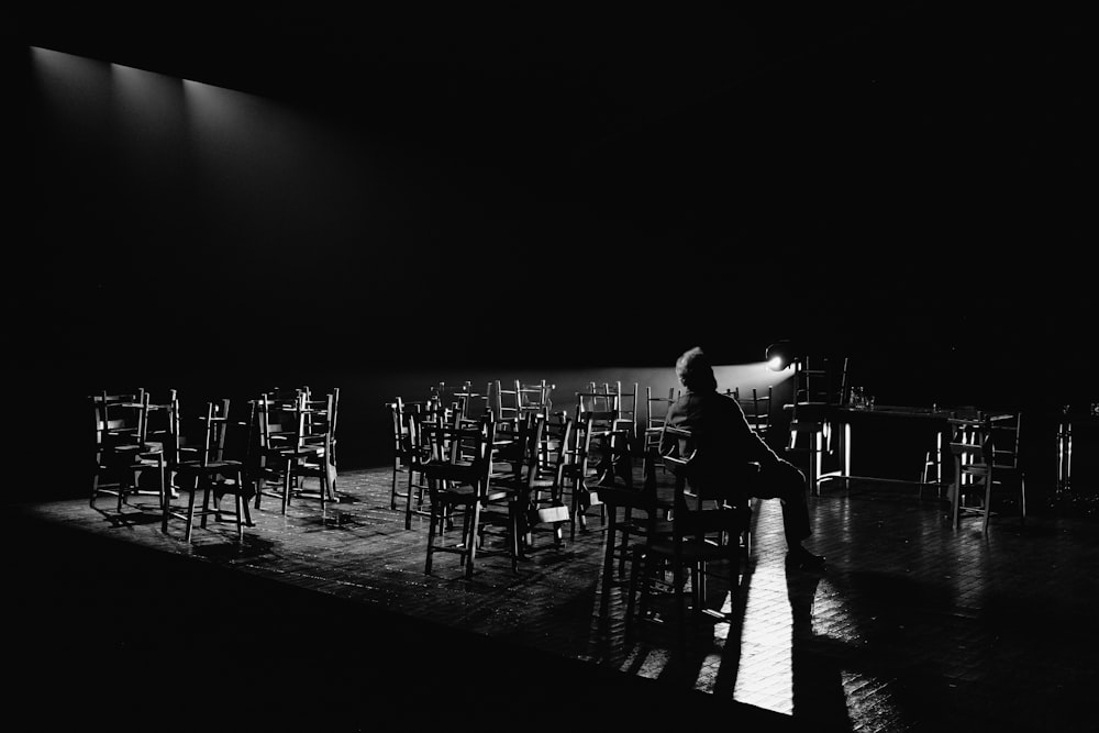 a person sitting on a chair in front of a row of chairs