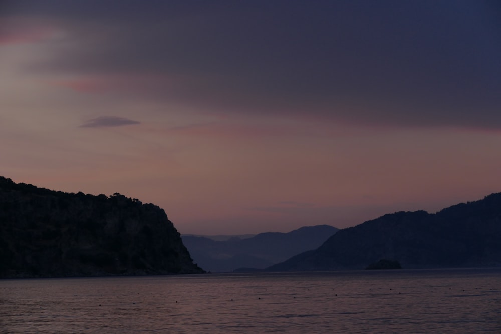 a body of water with hills in the background