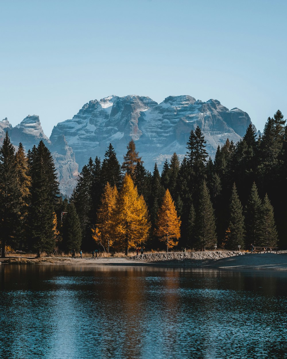 a lake with trees and mountains in the background