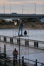 Technicians from savy & sons carefully inspecting a bridge restoration site under bright daylight.