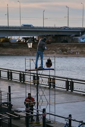 Technicians from savy & sons carefully inspecting a bridge restoration site under bright daylight.