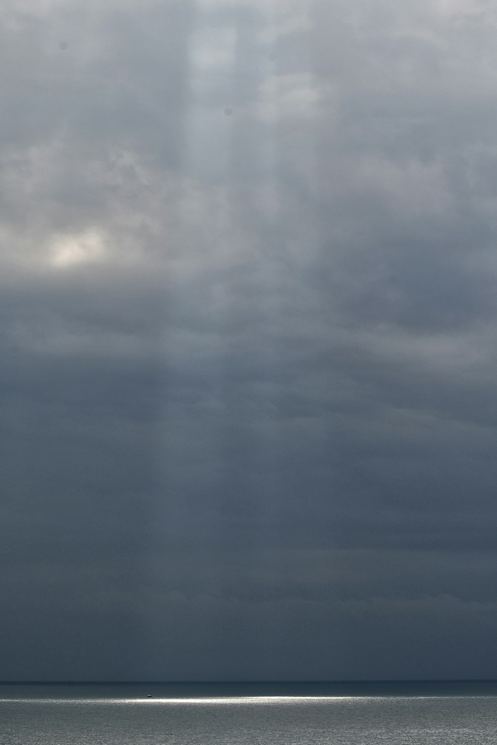 a body of water with clouds above it